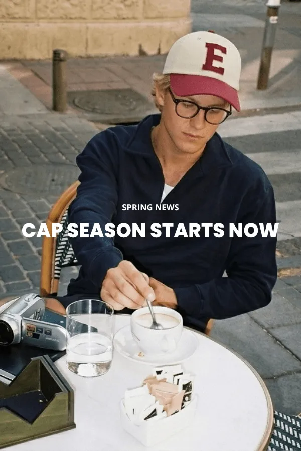 Un homme est assis sur une caisse en bois dans un studio et porte un chapeau de cowboy classique en feutre brun à large bord, une chemise en denim foncé et un jean.